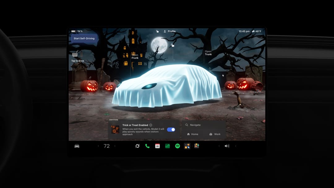 Tesla touchscreen showing the car as a glowing sheet ghost in a moonlit graveyard with jack-o'-lanterns, Trick or Treat enabled