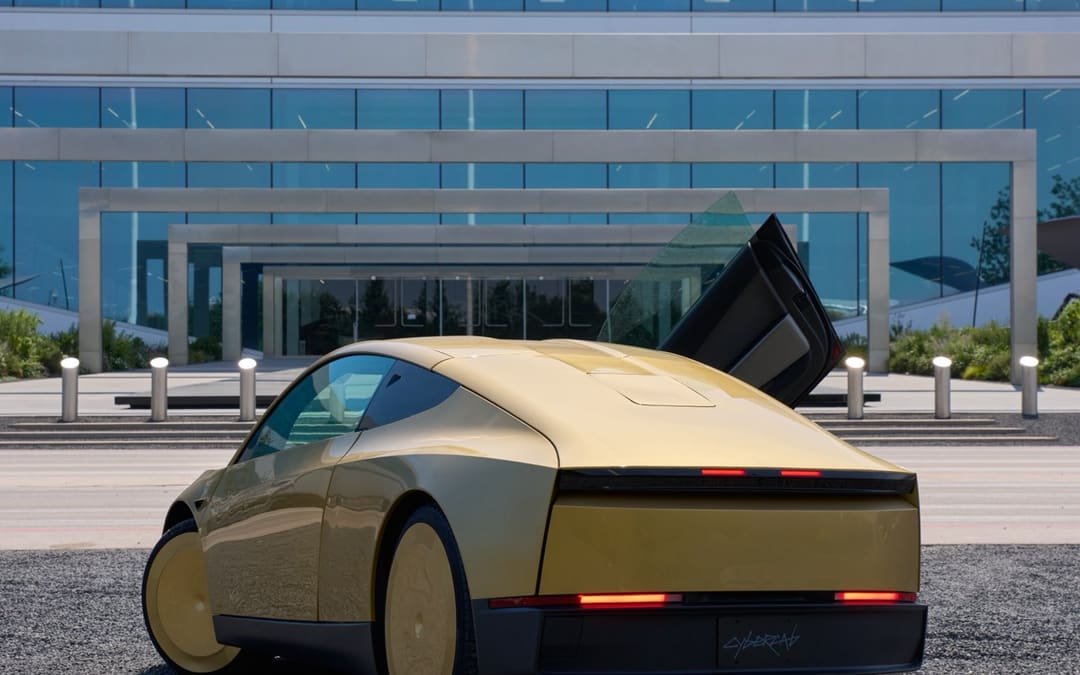 Gold Tesla Cybercab with a door open outside a Tesla building