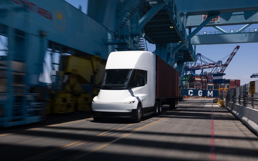Tesla Semi driving through a container port under the cranes